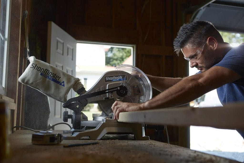 Man Works with Delta Master Miter Saw with Laser