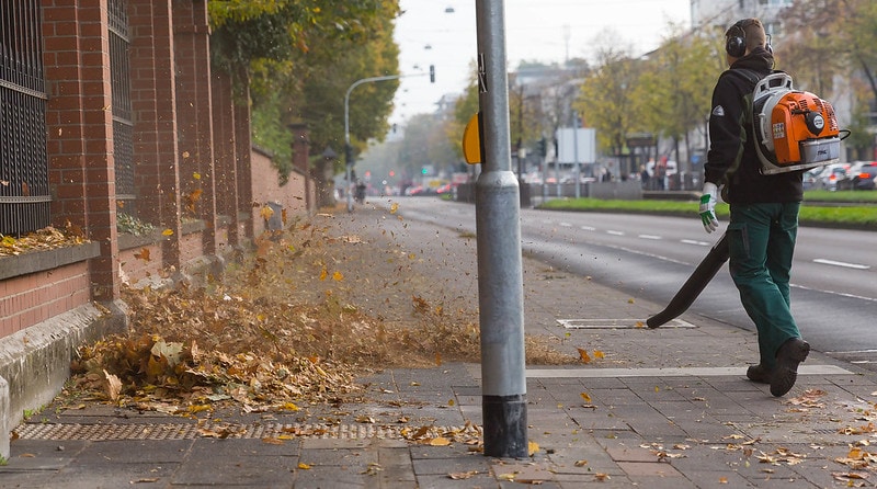 person with a leaf blower on street