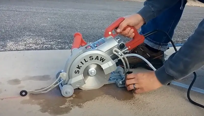 man cuts concrete with a saw