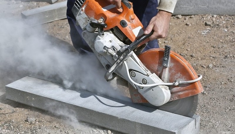 man cuts concrete with a saw