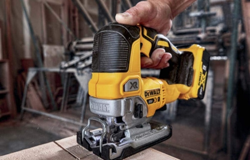 man cuts wood with a jigsaw