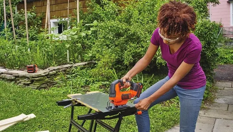 woman cuts wood with jigsaw