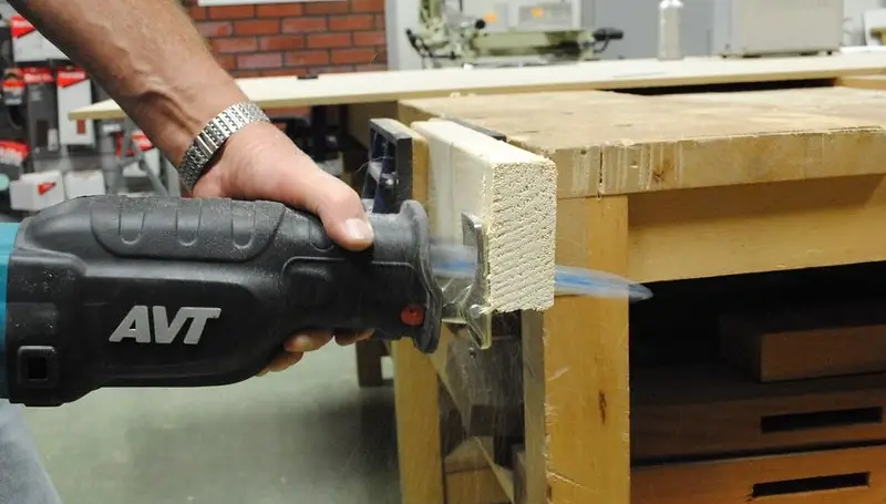man cuts wood with reciprocating saw