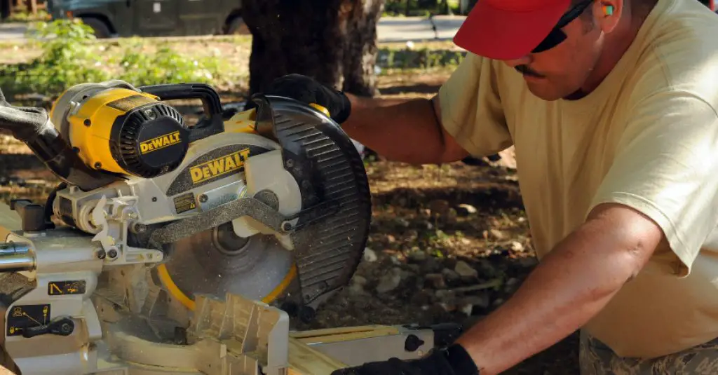 Woodworker using sliding mitre saw