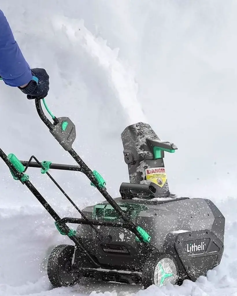 Man with Green Snow Thrower Cleans Snow