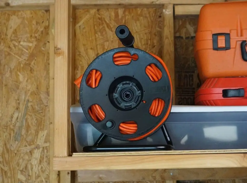 The extension cord reel is on the shelf