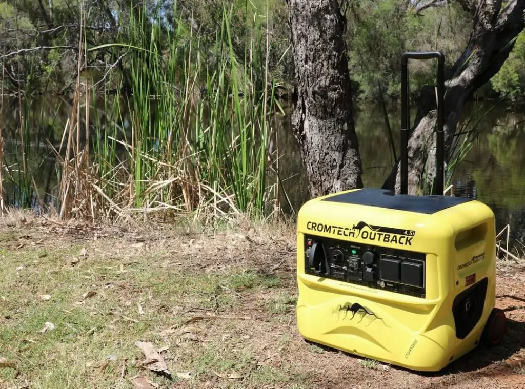 portable yellow generator on the bank of the pond