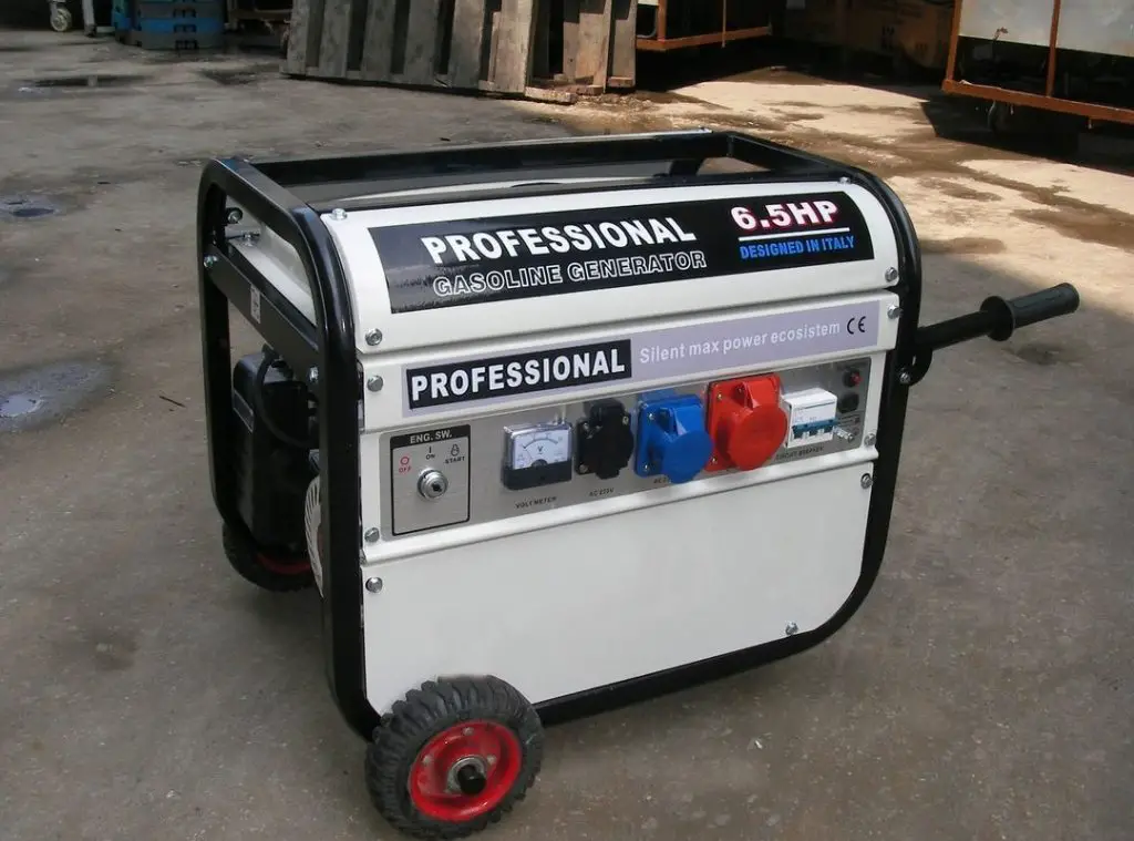 White portable generator with red wheels stands outside