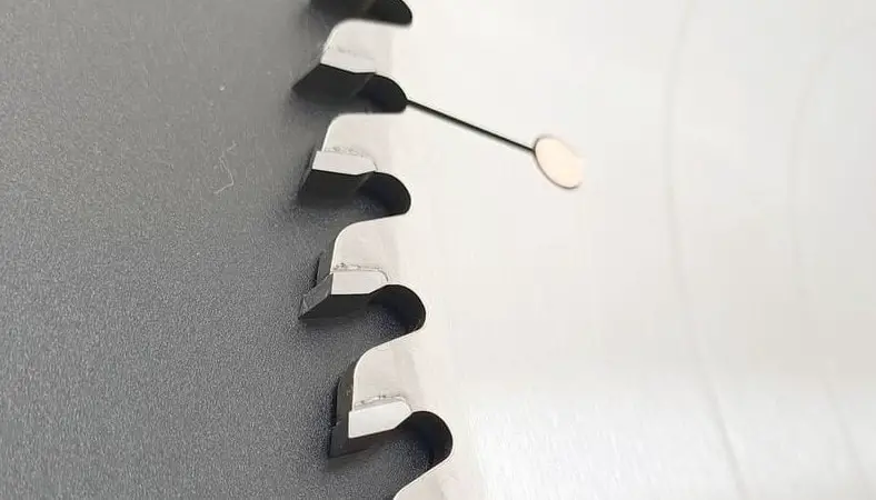 Saw blade on the grey surface