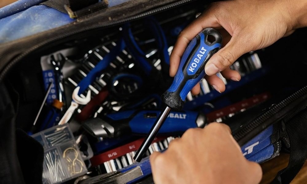 Man puts screwdriver in Kobalt tool bag